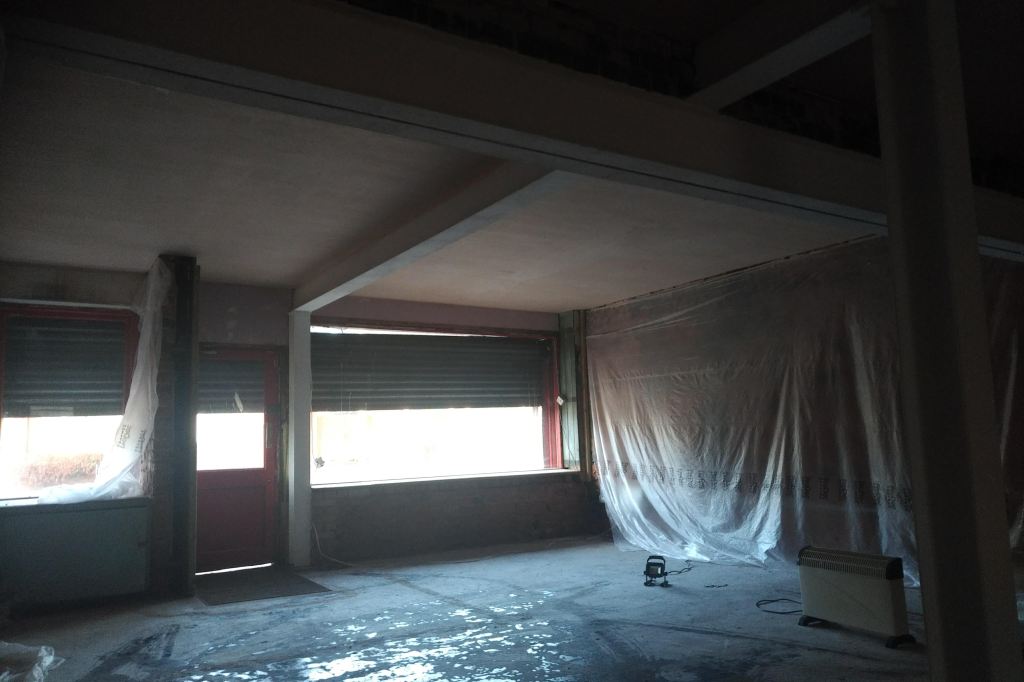the interior of a small shop showing a room under renovation
