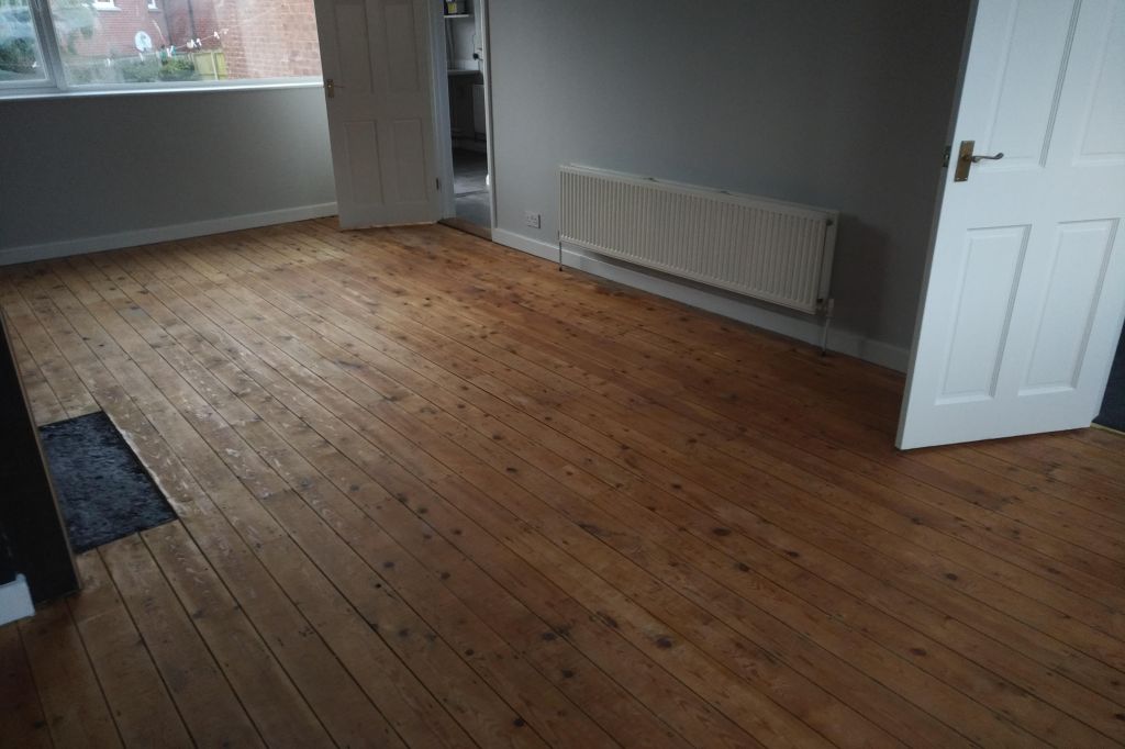 a living room showing exposed wooden floor